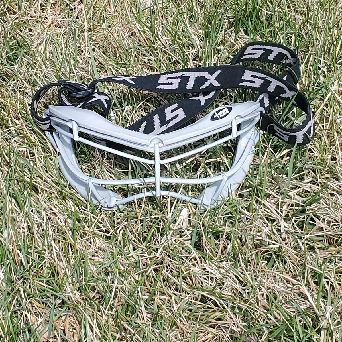 picture-of-girls-lacrosse-goggles-laying-in-grass-best-lax-goggles-for-girls